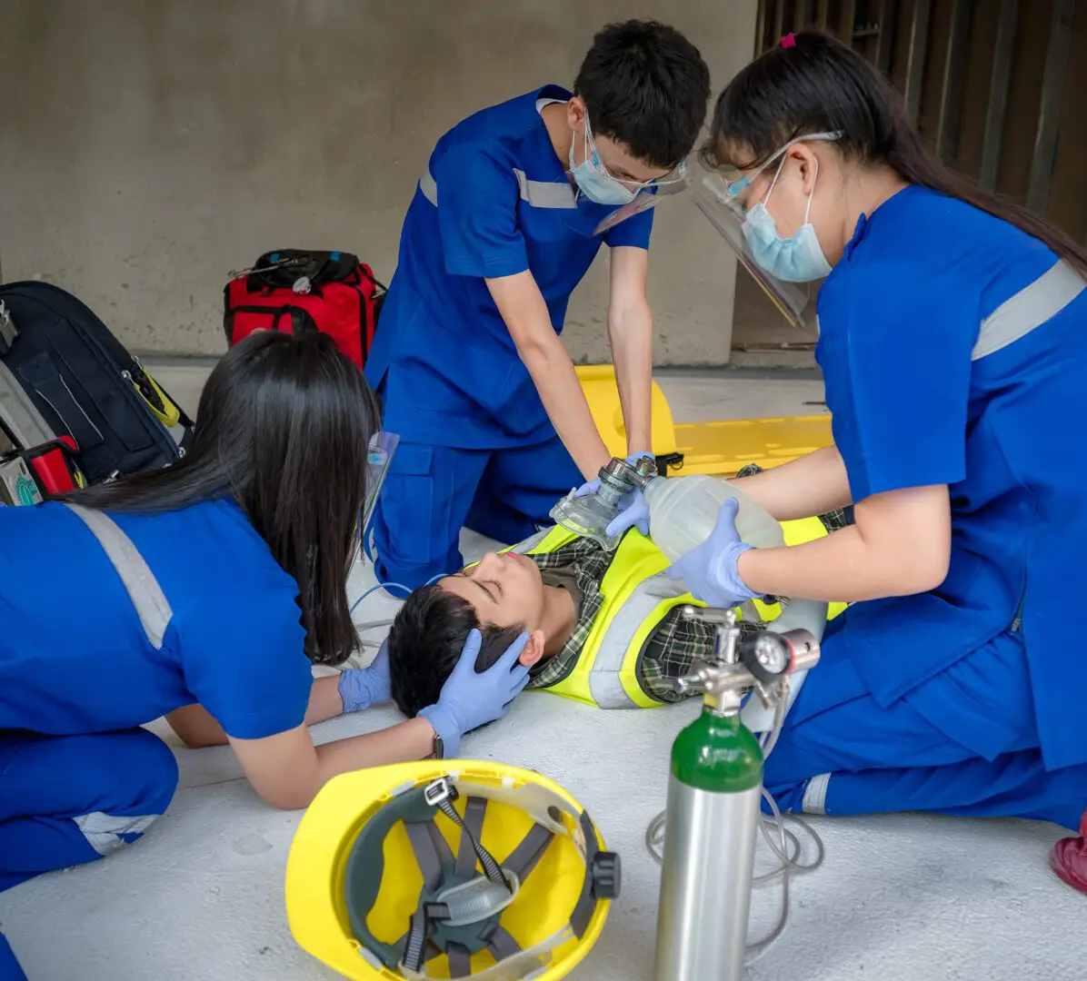 Medical team assisting a patient on ground.